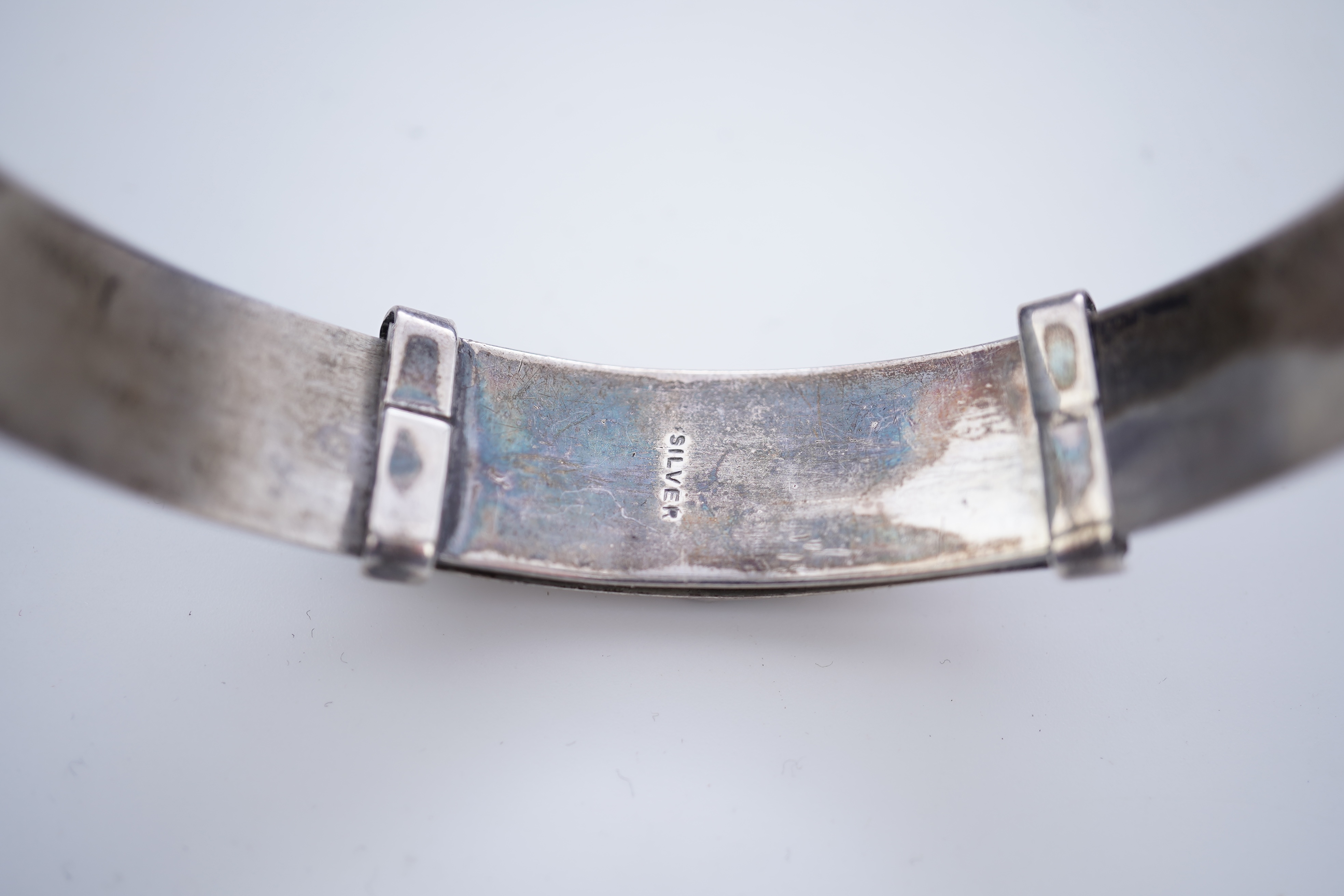 A collection of silver jewels, comprising: a bangle; a chain necklace suspending two winding toothpicks, one with toothpick deficient; a rope twist chain; a pair of cufflinks with the initials DBH; a pendant of abstract